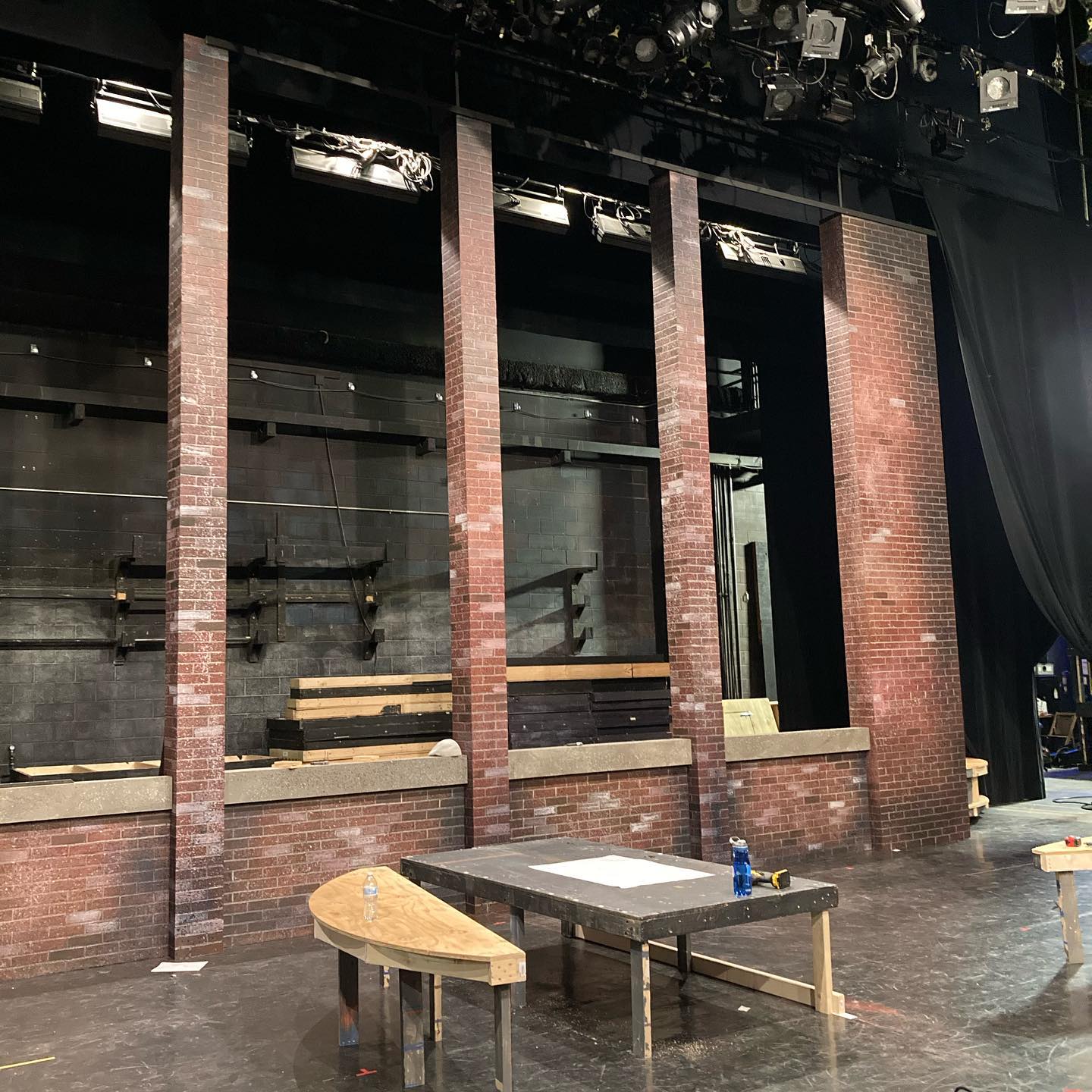 On stage: partial walls painted to look like bricks, with some platforms.